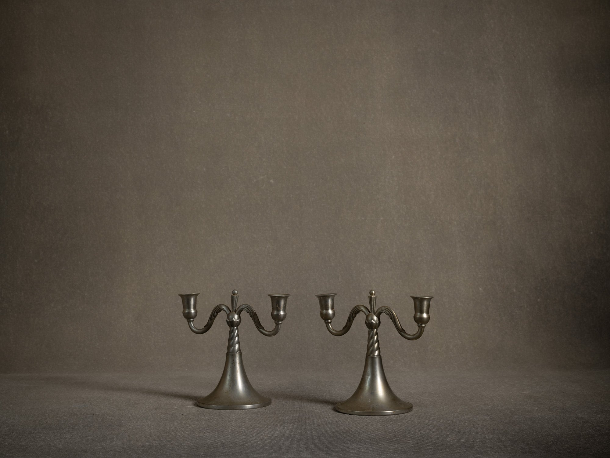 Paire de bougeoirs / candélabres de table en étain par Lundin & Lindberg Svenskt Tenn, Suède (1933-34)..Pair of pewter candle holders / table candelabra by Lundin & Lindberg Svenskt Tenn, Sweden (1933-34)