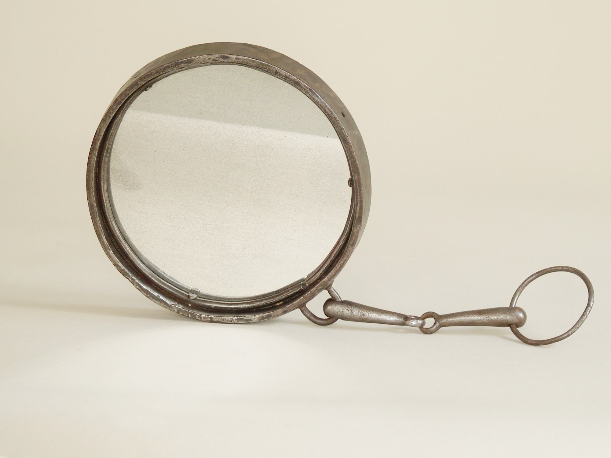 Miroir circulaire mural suspendu en fer battu, France (vers 1960)..Castiron wall hanging mirror, France (circa 1960)