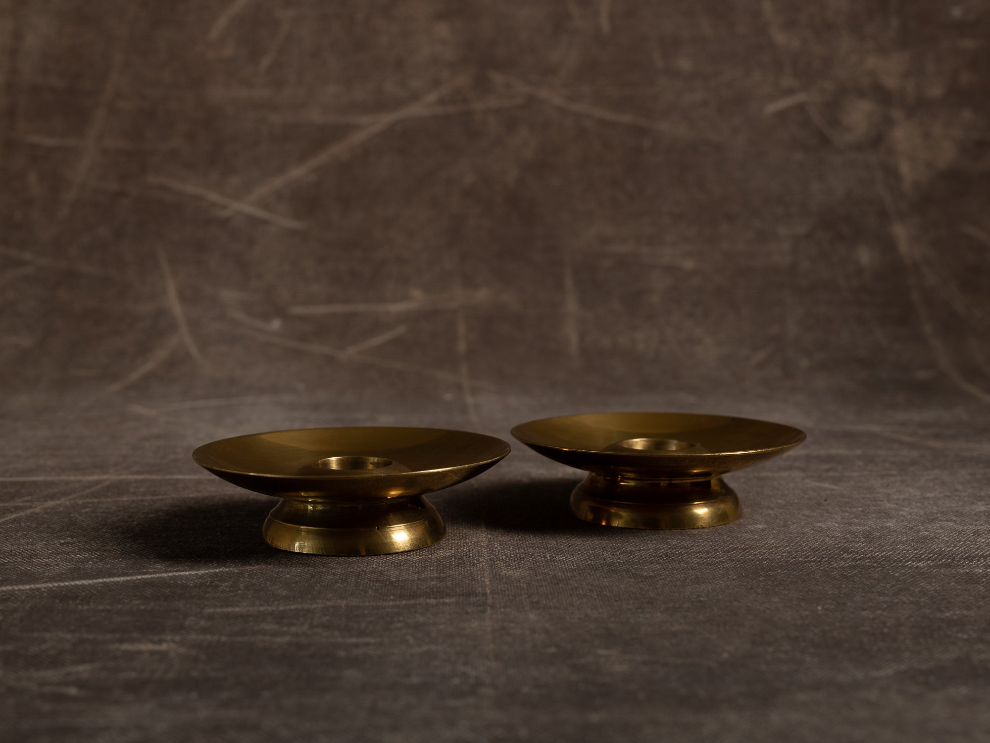 Paire de flambeaux soucoupe en laiton, Suède (vers 1965)..Pair of brass candle holders, Sweden (circa 1965)