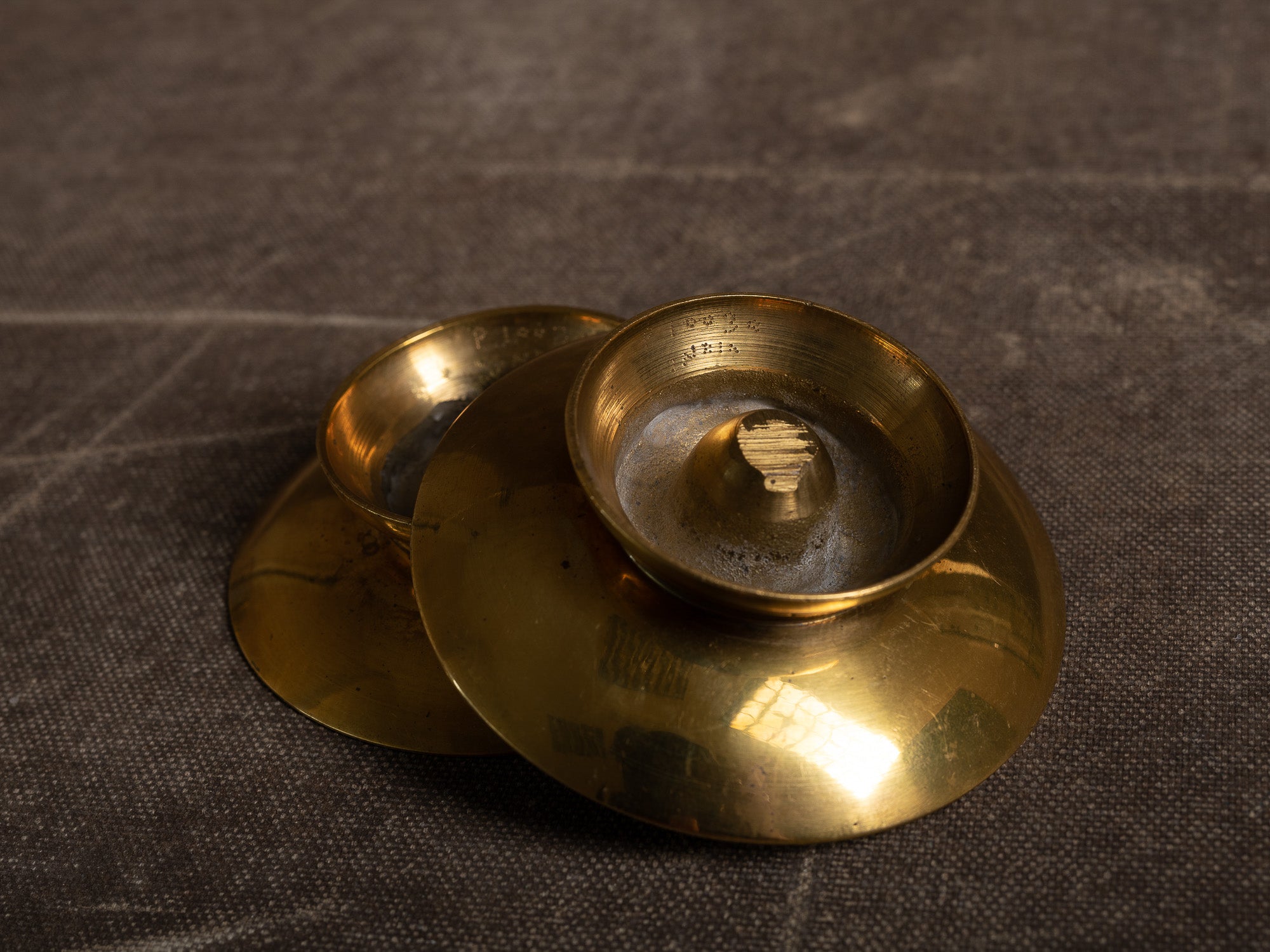 Paire de flambeaux soucoupe en laiton, Suède (vers 1965)..Pair of brass candle holders, Sweden (circa 1965)