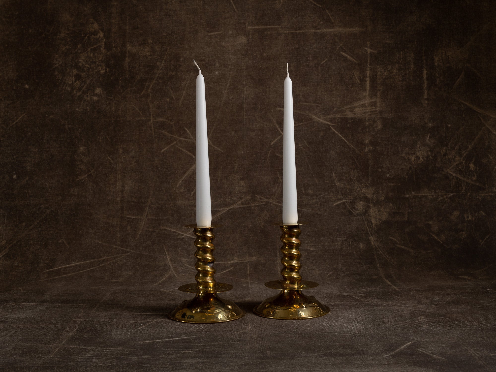 Paire de flambeaux baroques en laiton fourré, Suède (vers 1880-1900)..Pair of baroque brass candle holders, Sweden (circa 1880-1900)