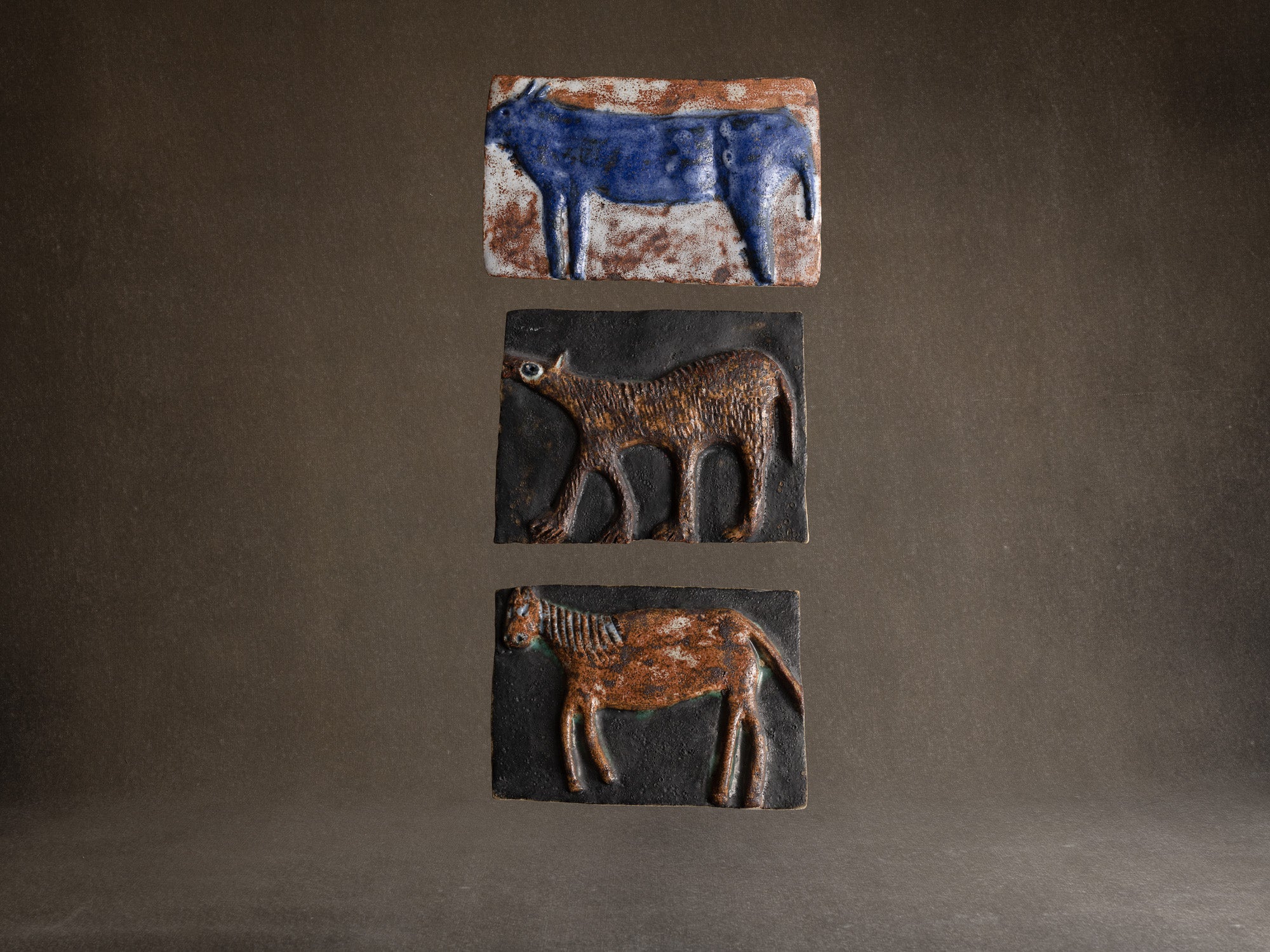 Suite de trois plaques en terre chamottée à décor animalier, Scandinavie (vers 1960)..Set of 3 ceramic wall plaque with animal patterns, Scandinavia (1960's)