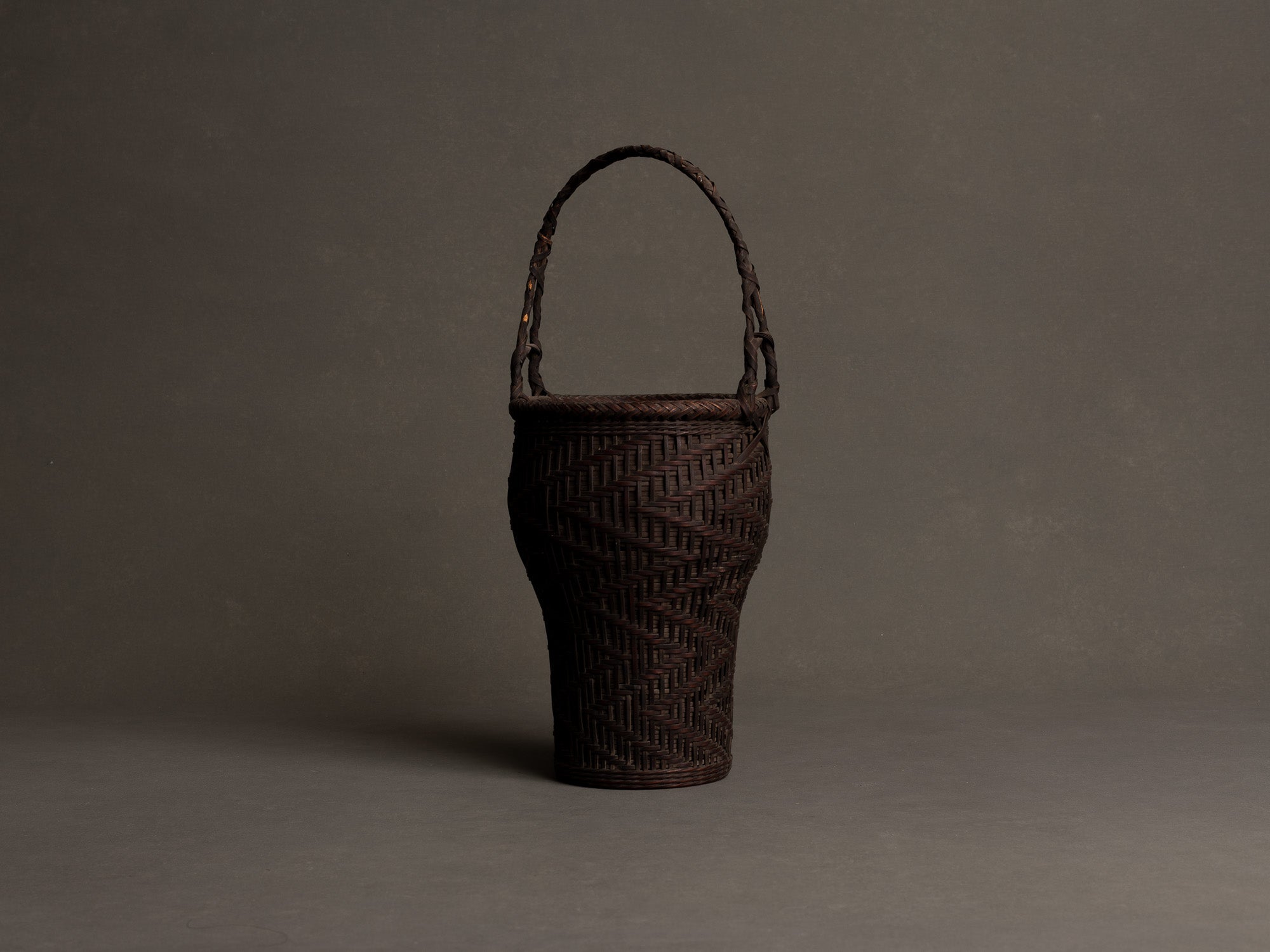 Hanakago, panier à anse pour l'ikebana en bambou nemagaridake, Japon (fin de l’ère Meiji / ère Taishō)..Hanakago Ikebana nemagaridake bamboo basket with handle, Japan (Late Meiji era / Taishō era)