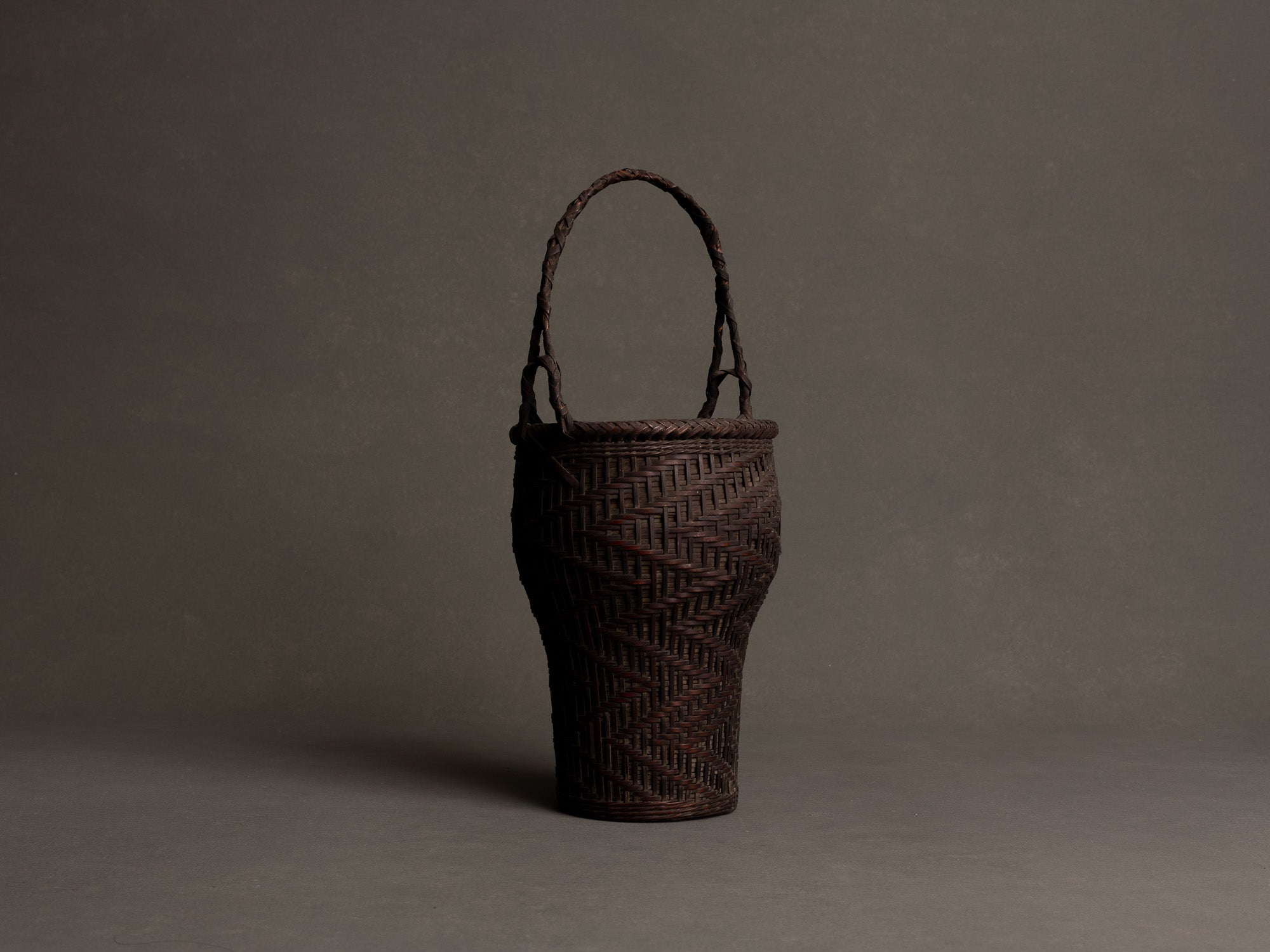Hanakago, panier à anse pour l'ikebana en bambou nemagaridake, Japon (fin de l’ère Meiji / ère Taishō)..Hanakago Ikebana nemagaridake bamboo basket with handle, Japan (Late Meiji era / Taishō era)