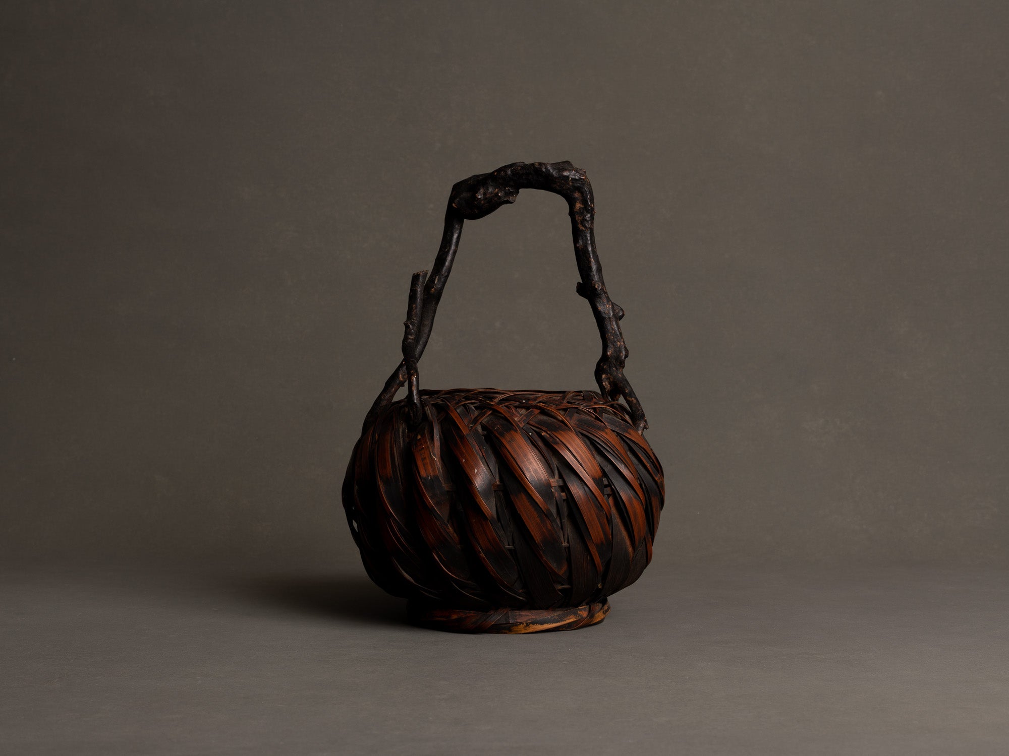 Hanakago, panier boule à anse branchée pour l'ikebana, Japon (Fin ère Meiji à début ère Shōwa)..Hanakago, Ikebana bamboo basket flower vase with wood handle, Japan (Late Meiji era to Early Shōwa era)
