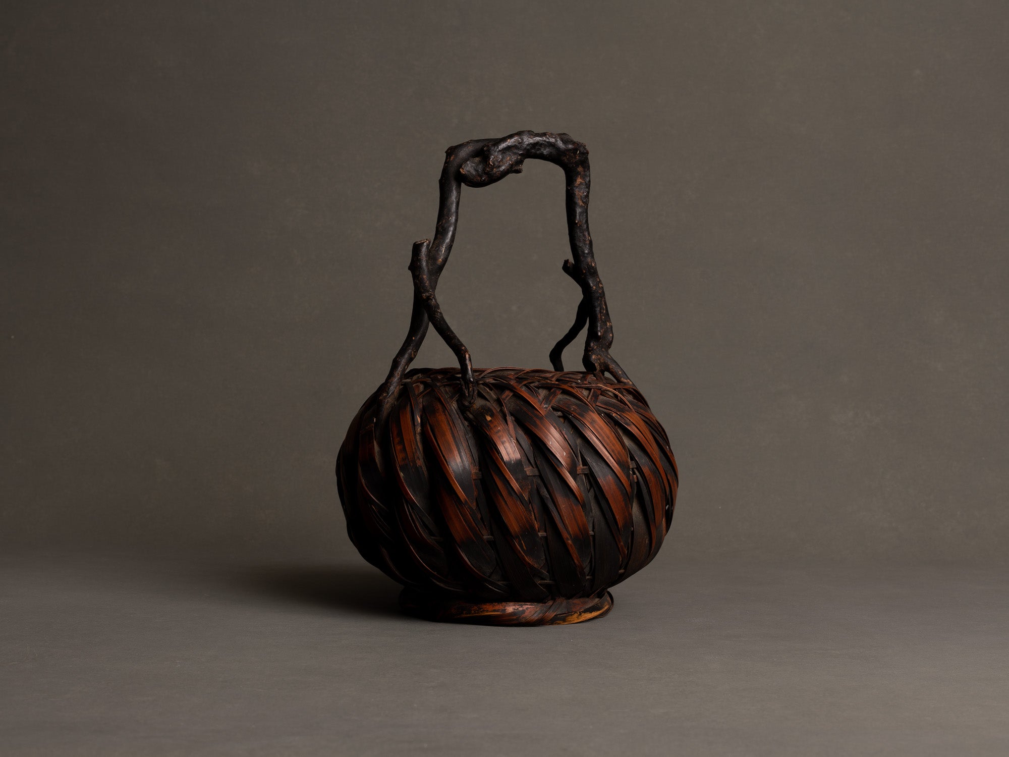 Hanakago, panier boule à anse branchée pour l'ikebana, Japon (Fin ère Meiji à début ère Shōwa)..Hanakago, Ikebana bamboo basket flower vase with wood handle, Japan (Late Meiji era to Early Shōwa era)