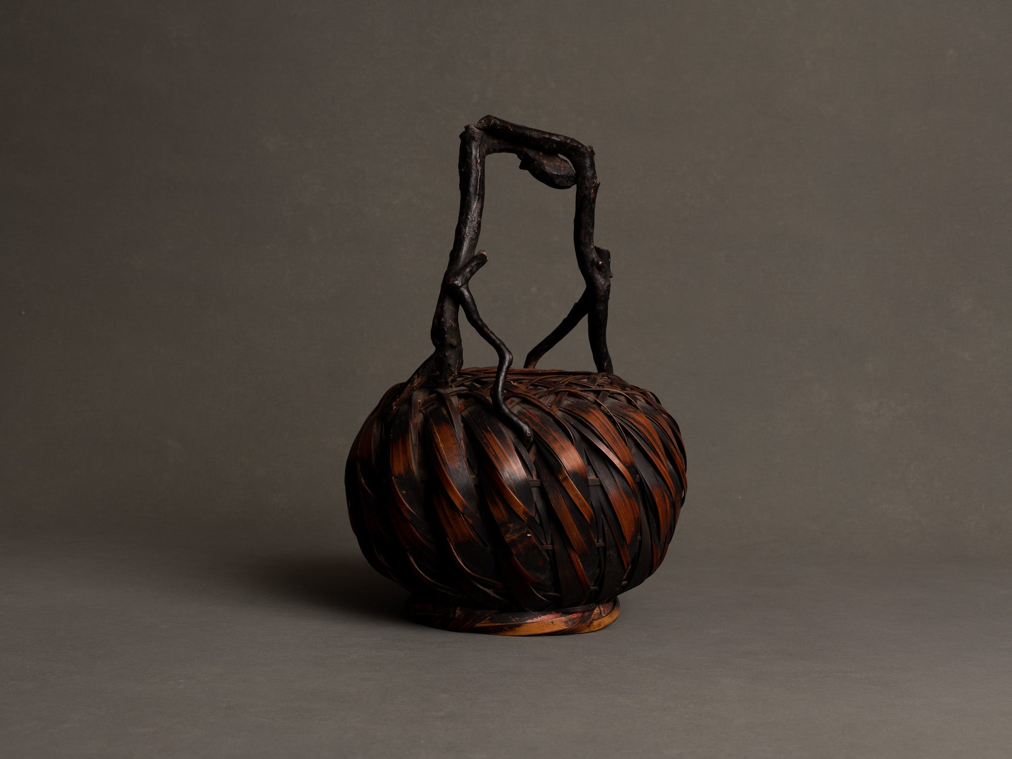 Hanakago, panier boule à anse branchée pour l'ikebana, Japon (Fin ère Meiji à début ère Shōwa)..Hanakago, Ikebana bamboo basket flower vase with wood handle, Japan (Late Meiji era to Early Shōwa era)