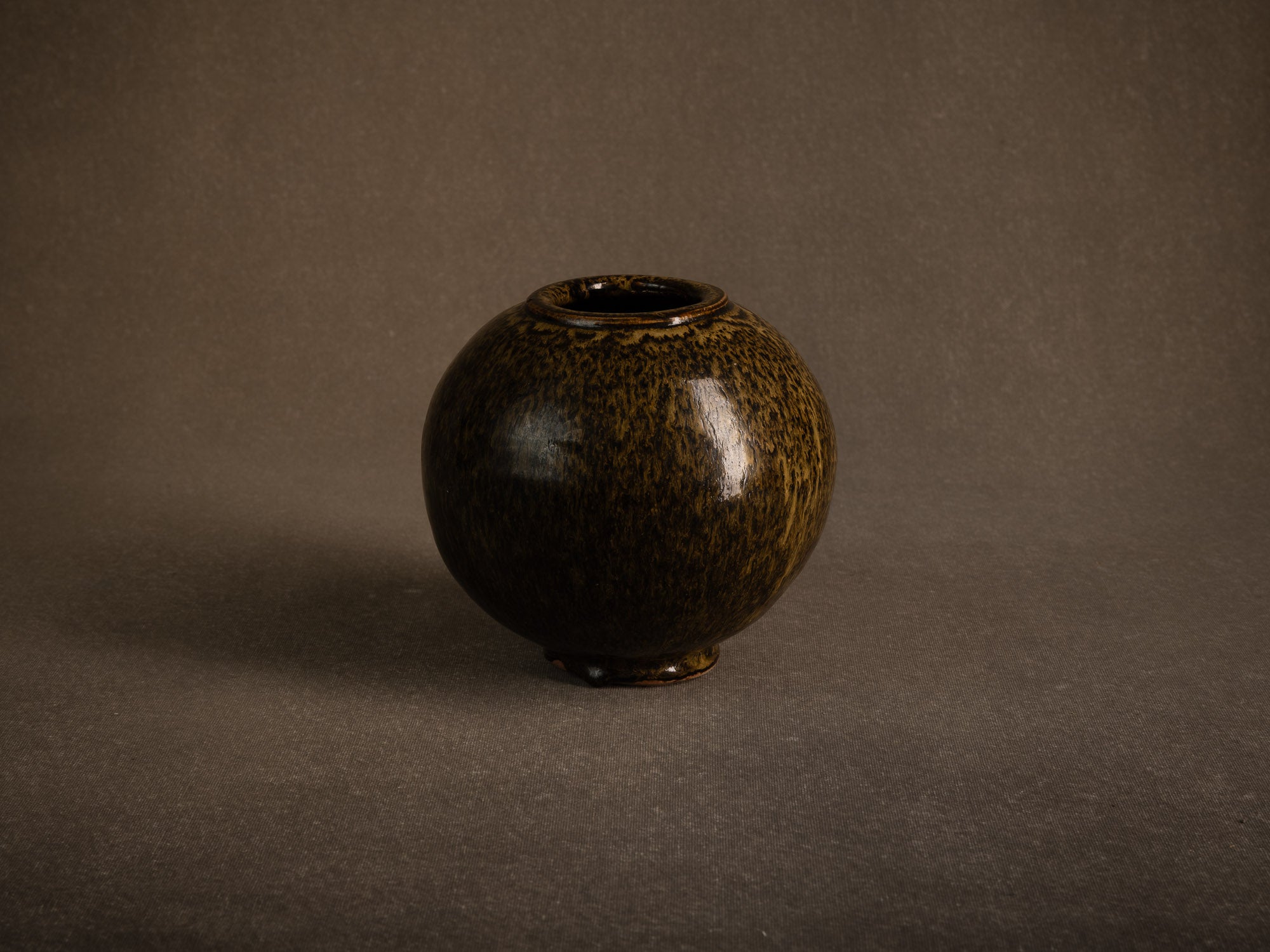 Vase boule en grès à émail goutte d'huile, France (circa 1980)..Stoneware sphere vase with oil-spot glaze, France (circa 1980)