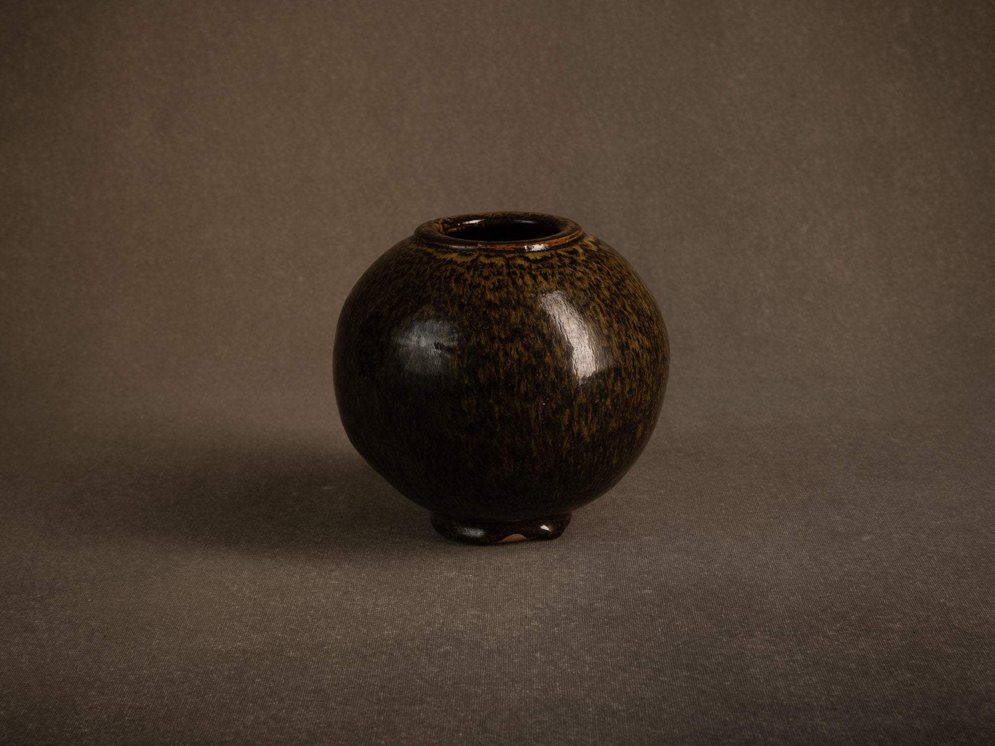 Vase boule en grès à émail goutte d'huile, France (circa 1980)..Stoneware sphere vase with oil-spot glaze, France (circa 1980)