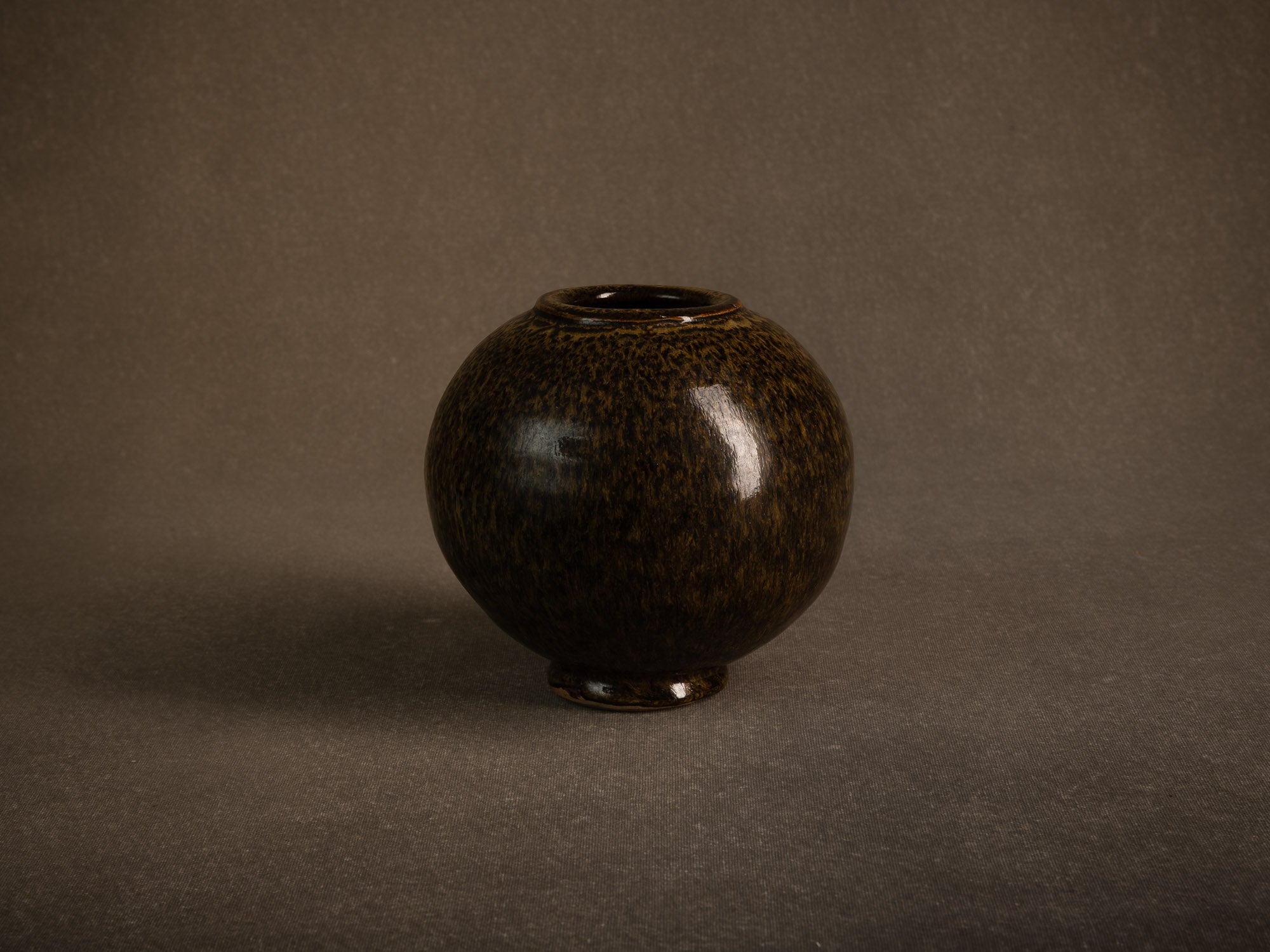 Vase boule en grès à émail goutte d'huile, France (circa 1980)..Stoneware sphere vase with oil-spot glaze, France (circa 1980)