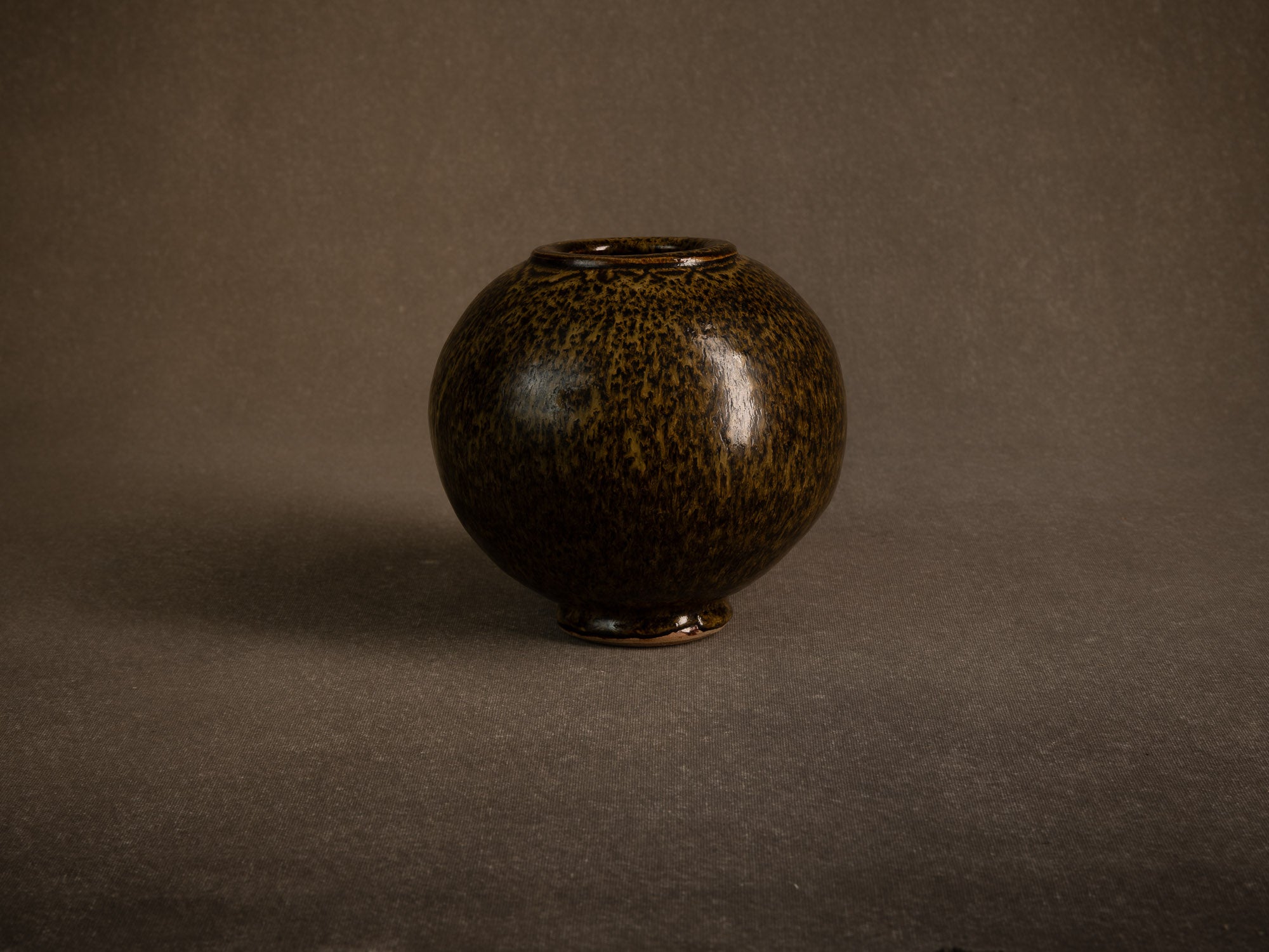 Vase boule en grès à émail goutte d'huile, France (circa 1980)..Stoneware sphere vase with oil-spot glaze, France (circa 1980)