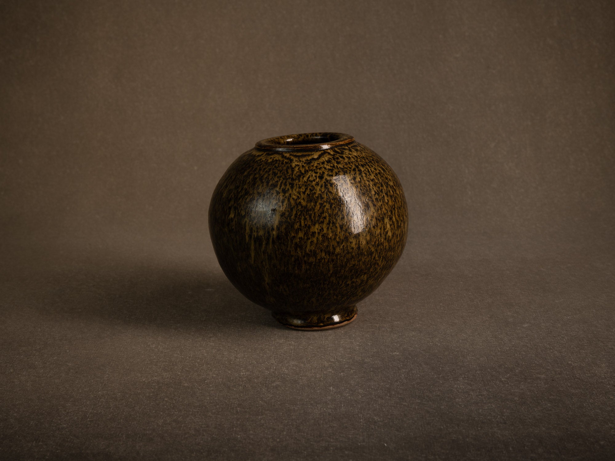Vase boule en grès à émail goutte d'huile, France (circa 1980)..Stoneware sphere vase with oil-spot glaze, France (circa 1980)