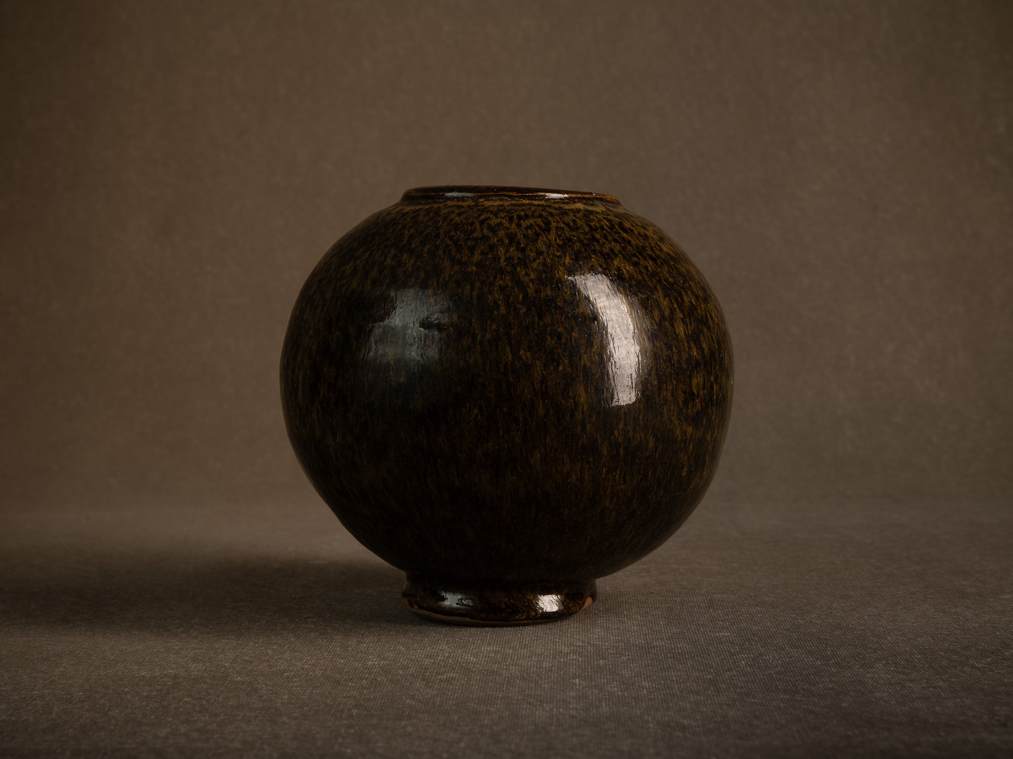 Vase boule en grès à émail goutte d'huile, France (circa 1980)..Stoneware sphere vase with oil-spot glaze, France (circa 1980)