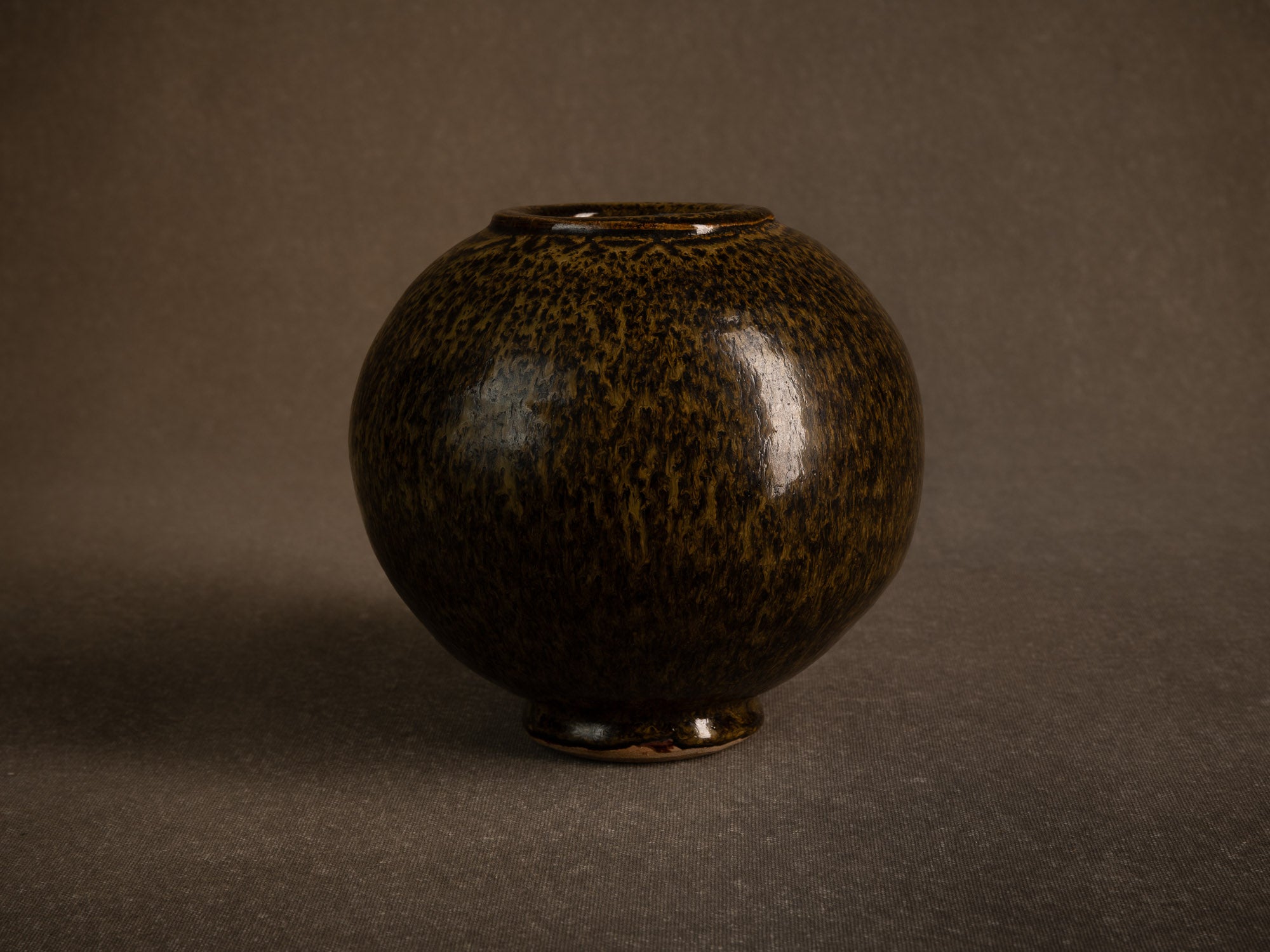 Vase boule en grès à émail goutte d'huile, France (circa 1980)..Stoneware sphere vase with oil-spot glaze, France (circa 1980)