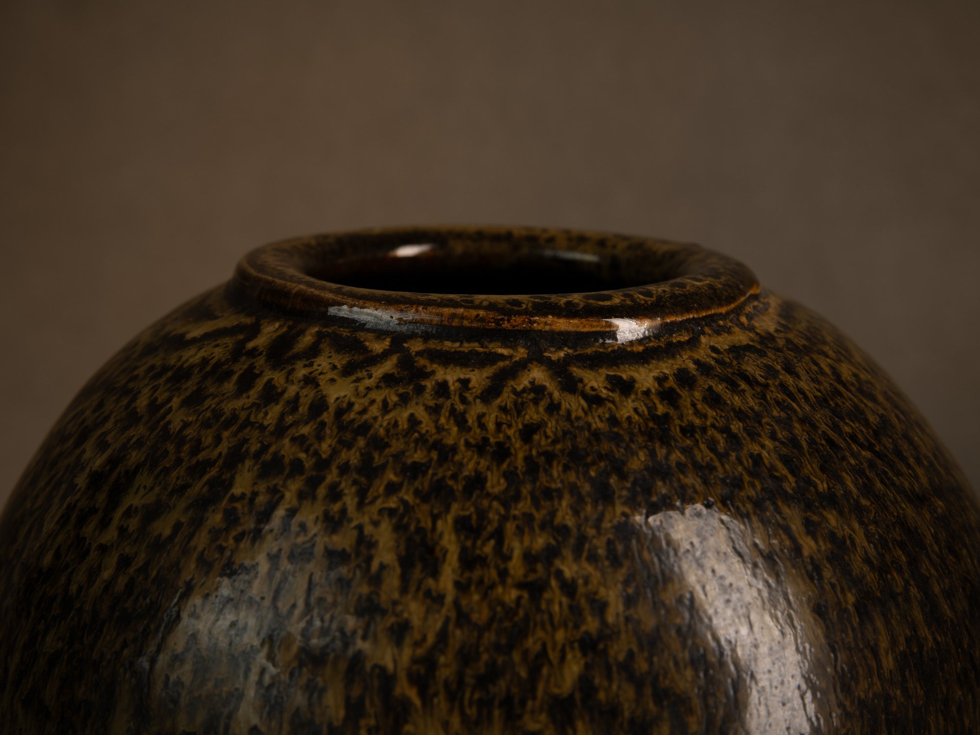 Vase boule en grès à émail goutte d'huile, France (circa 1980)..Stoneware sphere vase with oil-spot glaze, France (circa 1980)