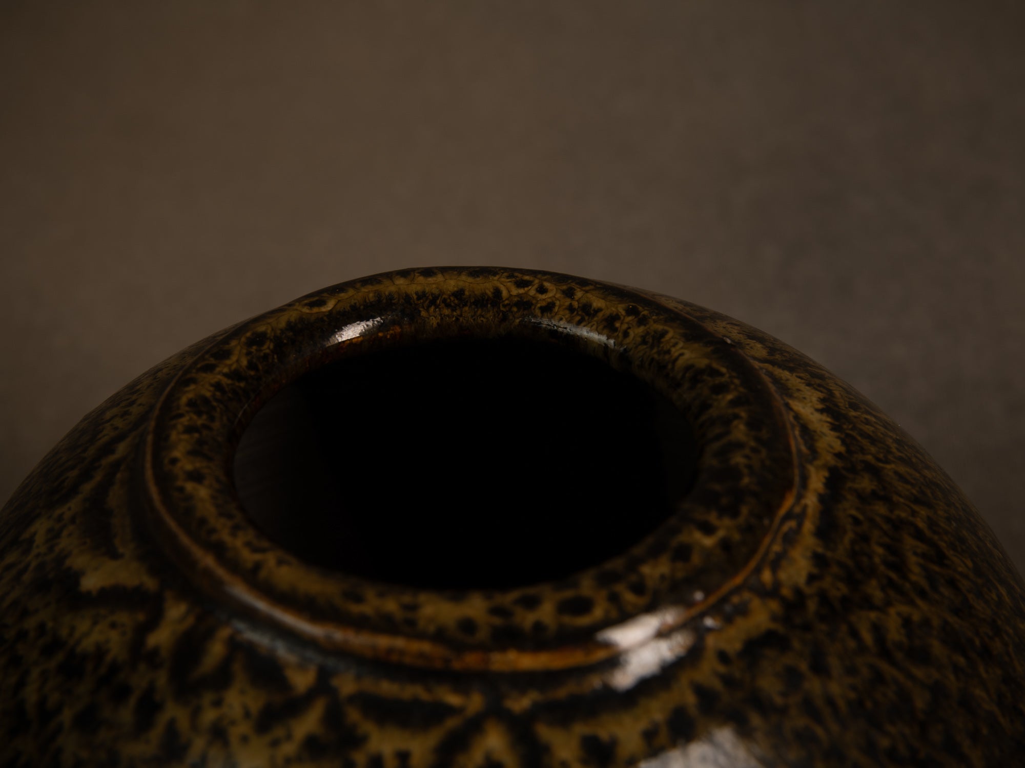 Vase boule en grès à émail goutte d'huile, France (circa 1980)..Stoneware sphere vase with oil-spot glaze, France (circa 1980)