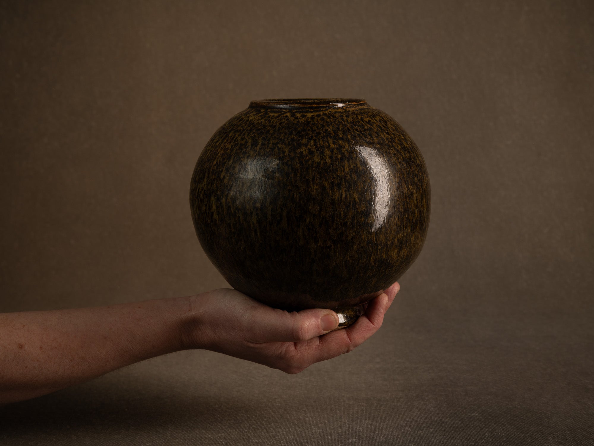 Vase boule en grès à émail goutte d'huile, France (circa 1980)..Stoneware sphere vase with oil-spot glaze, France (circa 1980)