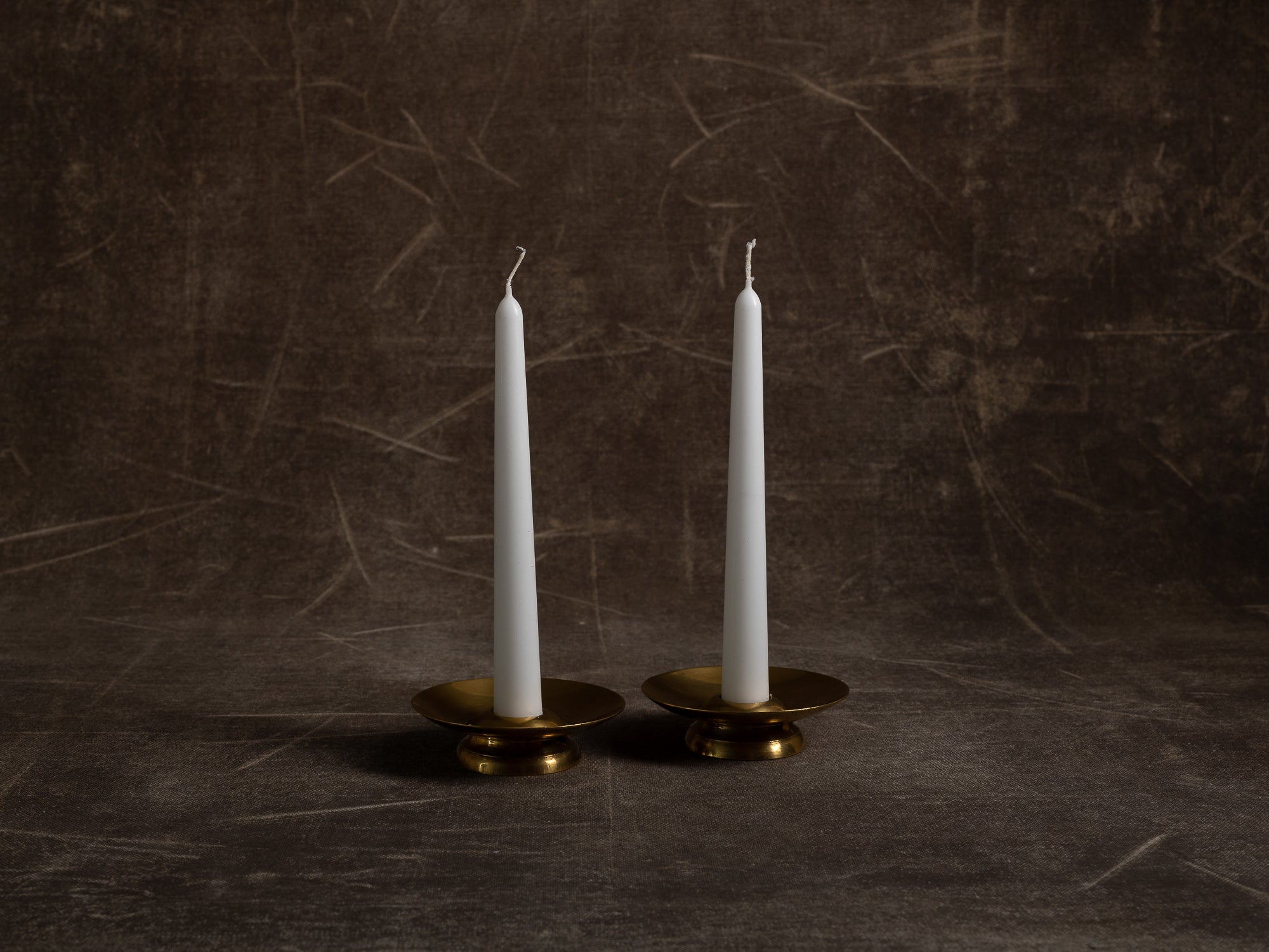 Paire de flambeaux soucoupe en laiton, Suède (vers 1965)..Pair of brass candle holders, Sweden (circa 1965)