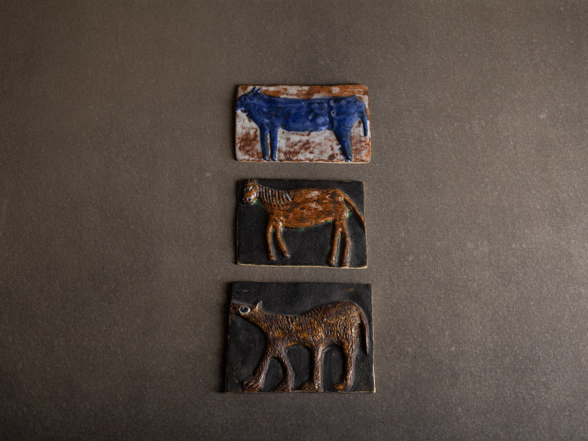 Suite de trois plaques en terre chamottée à décor animalier, Scandinavie (vers 1960)..Set of 3 ceramic wall plaque with animal patterns, Scandinavia (1960's)