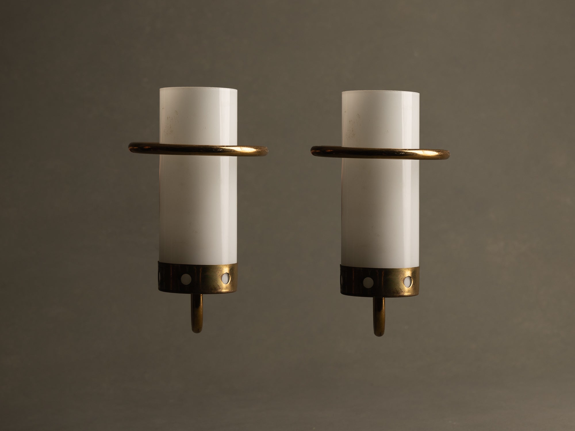 Paire d’appliques modernistes en opaline et laiton perforé, France (vers 1955-60)..Pair of modernist brass and glass wall lights sconces, France (circa 1955-60)